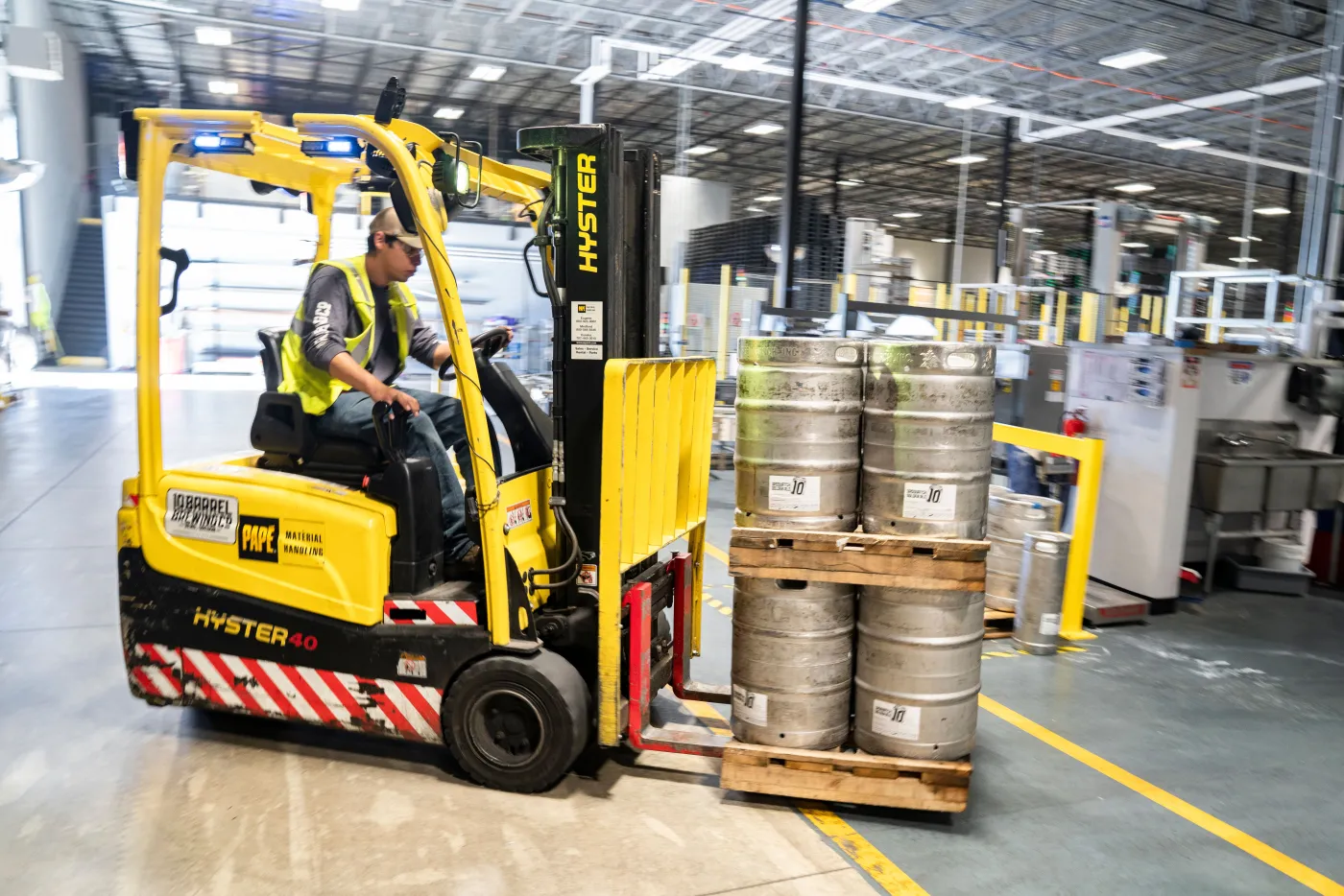 Industrial crew member in high-visibility safety gear working at a large facility