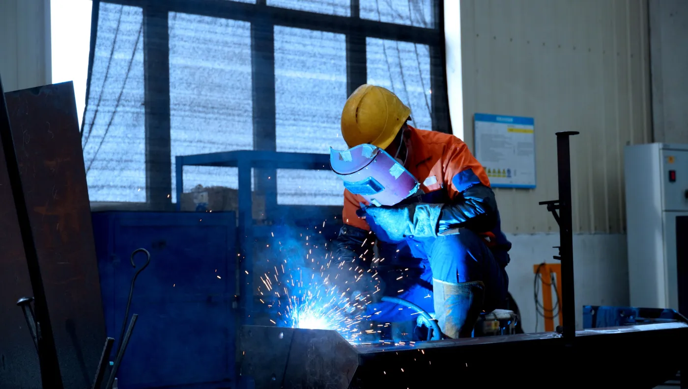 Frontline worker in a hard hat and high-visibility vest operating heavy equipment
